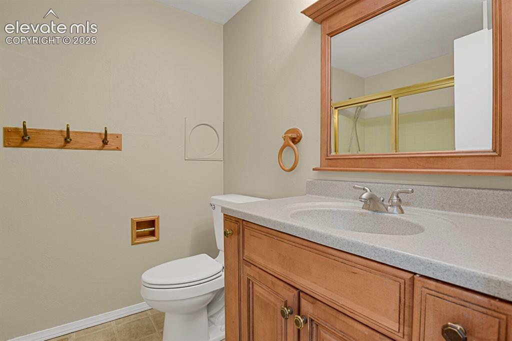 Image 19 of 34: Bathroom featuring a wood-finish vanity with an integrated sink and light-t