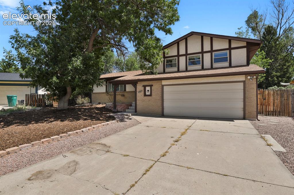 Image 2 of 34: Two-story residence featuring a two-car garage, brick facade, covered entry