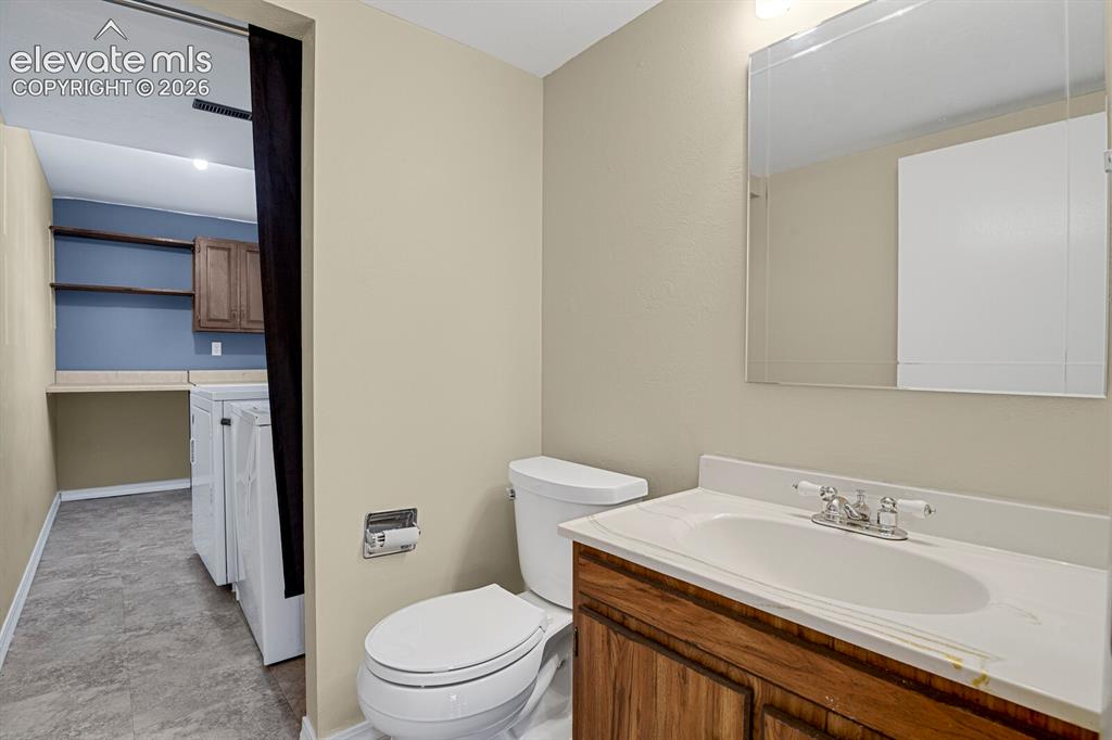 Image 23 of 34: Bathroom featuring a wood-finish vanity with an integrated sink and a recta