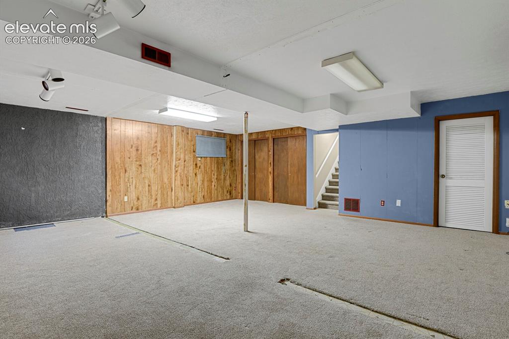 Image 26 of 34: Finished basement space featuring light-toned carpeting and overhead lighti