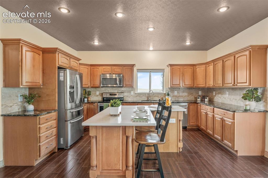 Image 12 of 49: Kitchen featuring wood-finish flooring, recessed lighting, wood cabinetry, 