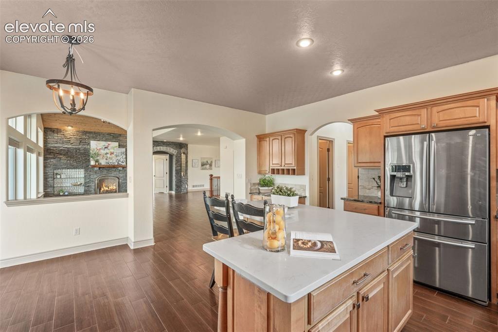 Image 15 of 49: Kitchen featuring a spacious island, stainless steel refrigerator, recessed