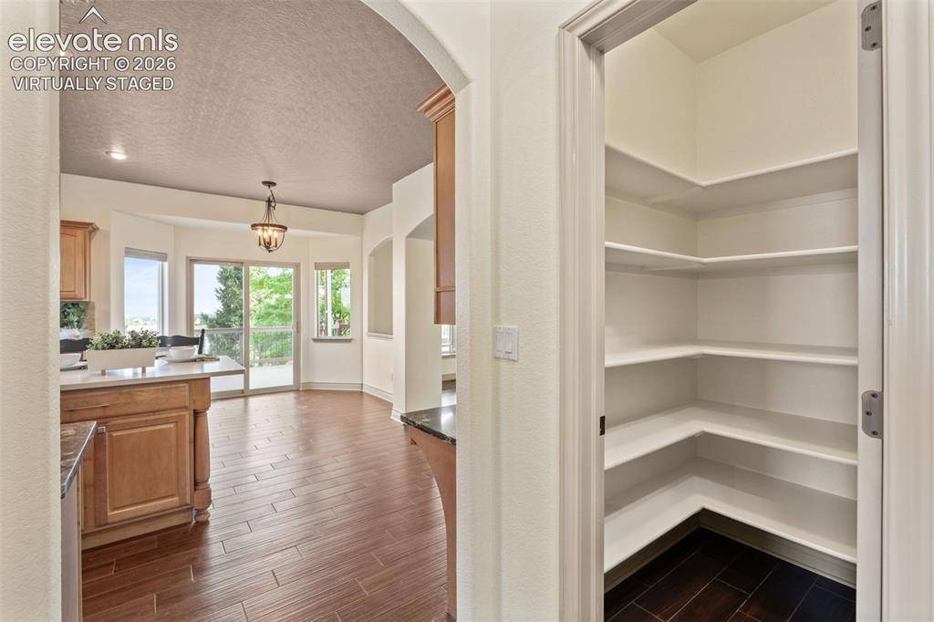 Image 17 of 49: Virtually Staged: Laundry room with wood-finish cabinetry, light-toned coun