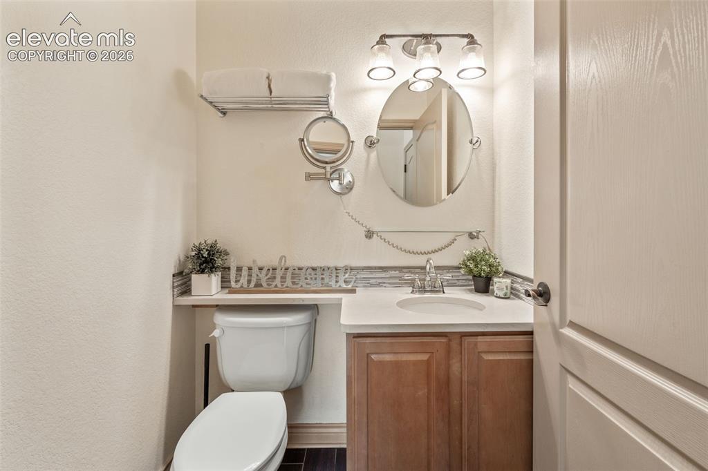 Image 20 of 49: Vanity with an integrated sink, wood-finish cabinetry, and a countertop