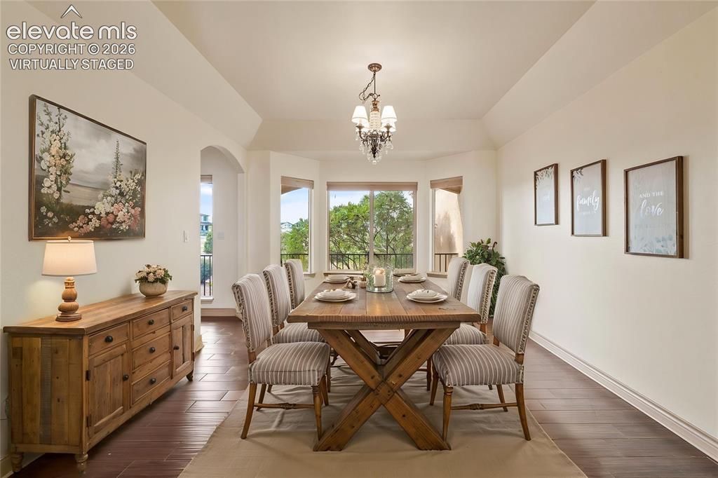 Image 21 of 49: Virtually Staged: Coved ceiling with a chandelier, bay windows, wood-finish