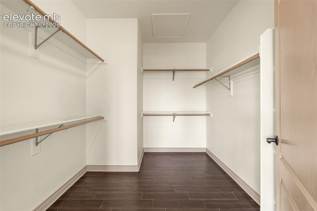 Image 25 of 49: Spacious closet featuring wood-finish flooring, multiple shelving units wit