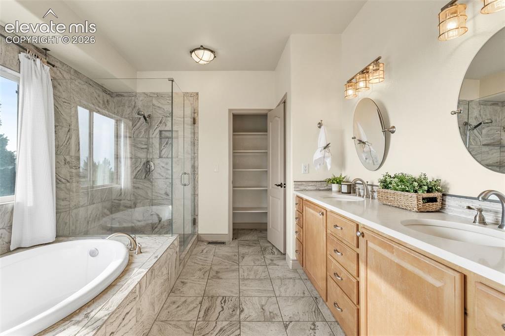 Image 26 of 49: Dual vanity with undermount sinks and light wood cabinetry