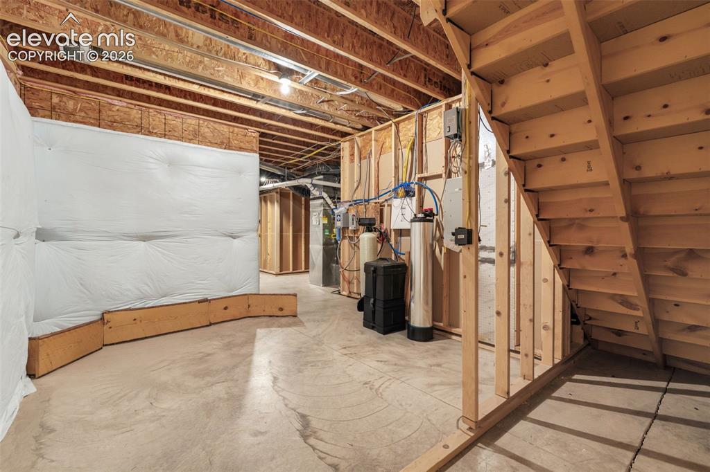 Image 36 of 49: Unfinished basement featuring exposed wood joists, framed walls, and a conc