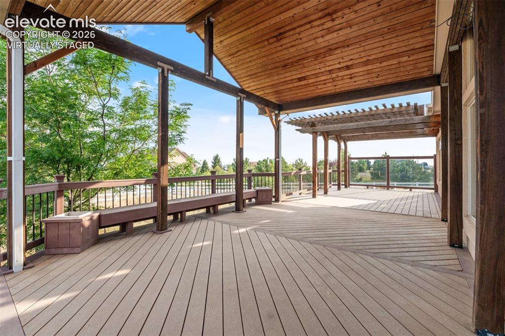 Image 38 of 49: Virtually Staged: Expansive outdoor deck featuring a vaulted wood-paneled c