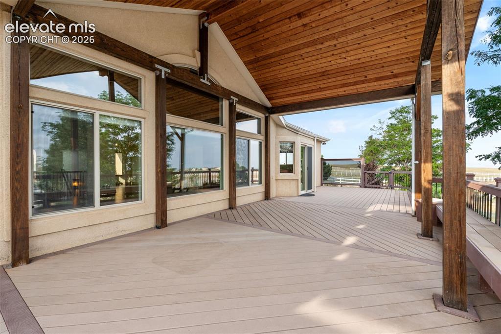 Image 40 of 49: Expansive covered deck featuring a textured composite surface and wood-plan