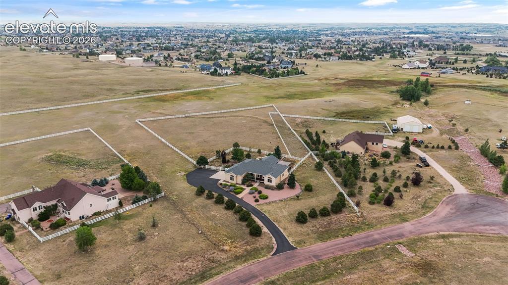 Image 45 of 49: Expansive property featuring multiple structures, paved driveways, a large