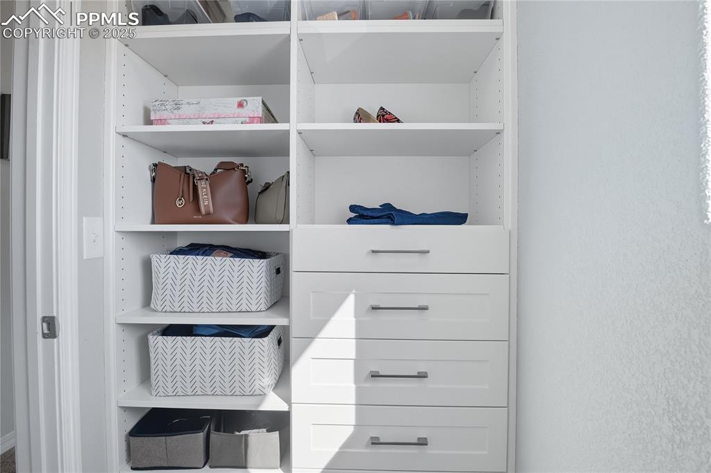 Image 16 of 31: CUSTOM WALK-IN CLOSET WITH BUILT-IN SHELVES