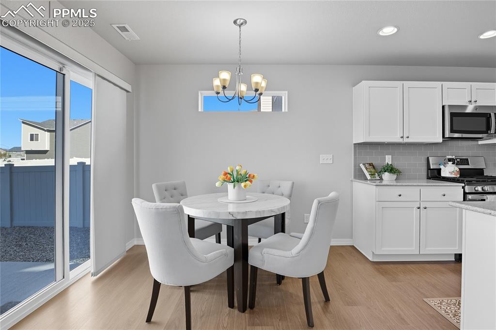 Image 9 of 31: DINING AREA WALKS-OUT TO THE SPACIOUS, FENCED BACKYARD