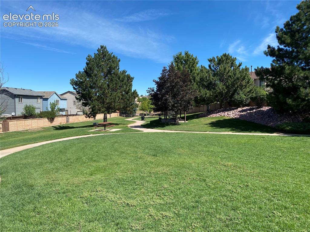 Image 41 of 44: Grassy area on other side of the basketball/tennis court, with walking path