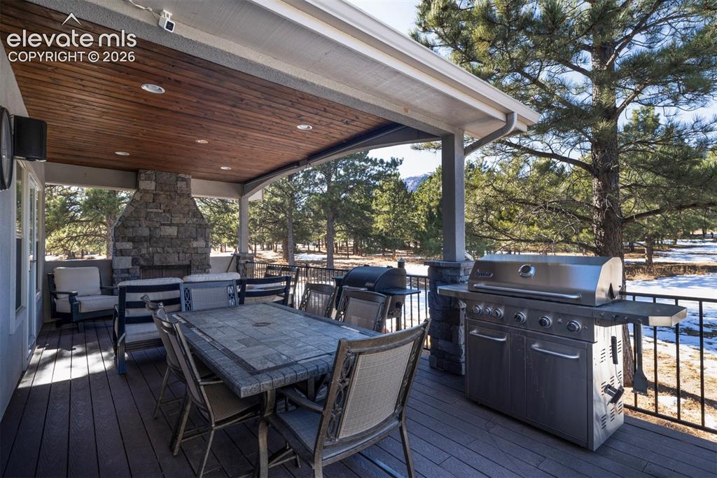 Image 37 of 44: Partial covered deck with built in fireplace