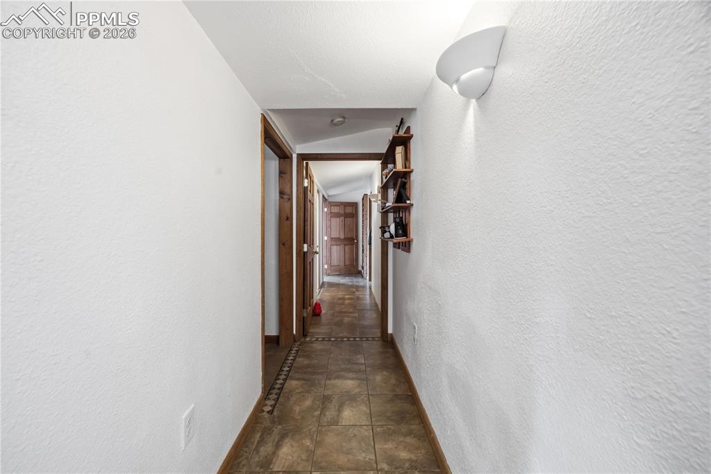 Image 22 of 47: Hall with a textured wall and vaulted ceiling