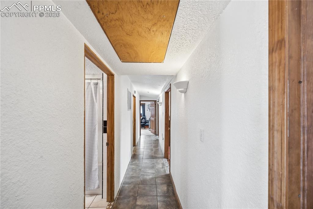 Image 27 of 47: Hall featuring a textured wall and a textured ceiling