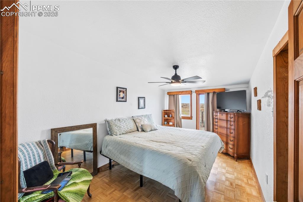Image 28 of 47: Bedroom featuring parquet flooring, a ceiling fan, and a textured ceiling
