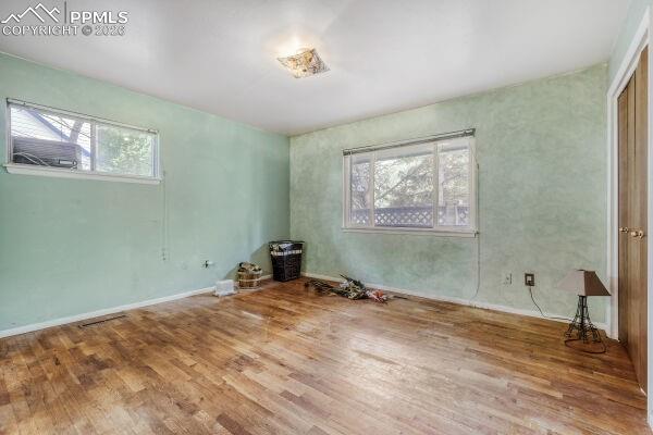 Image 10 of 29: Spacious interior featuring wood-finish flooring, a brick-clad fireplace, a