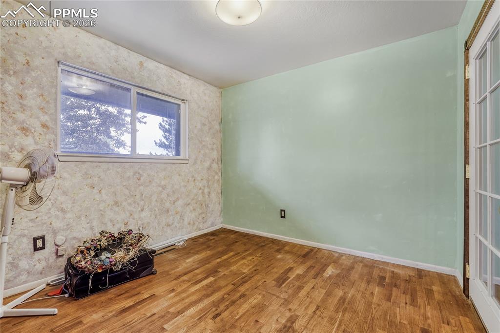 Image 15 of 29: Virtually Staged - Bedroom featuring wood-finish flooring, two windows, and
