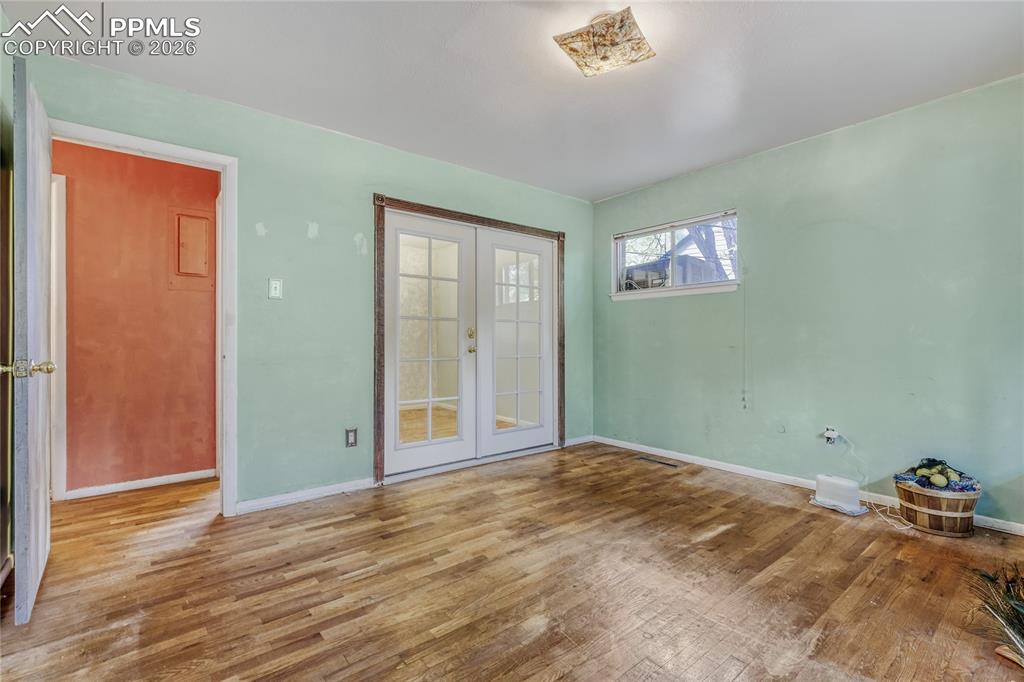 Image 18 of 29: Exposed brick fireplace with stone hearth and wood-finish flooring