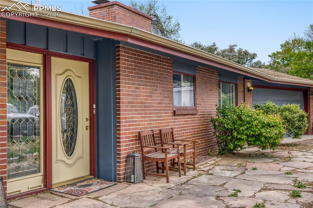 Image 2 of 29: Brick exterior with a blue accent façade and an attached garage