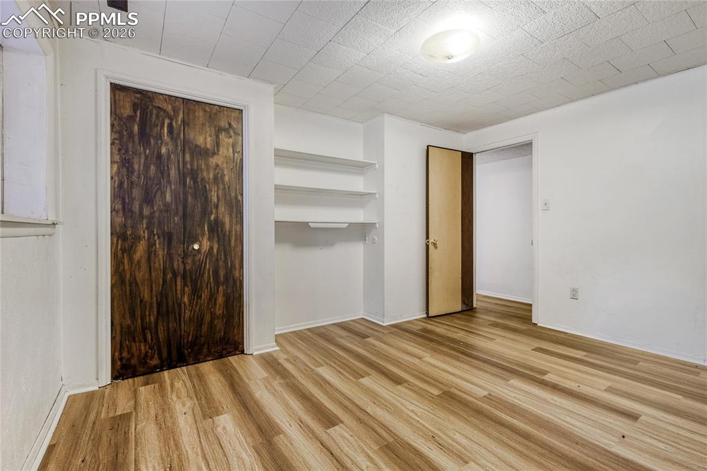 Image 22 of 29: Room featuring wood-finish flooring, white French doors, a horizontal windo