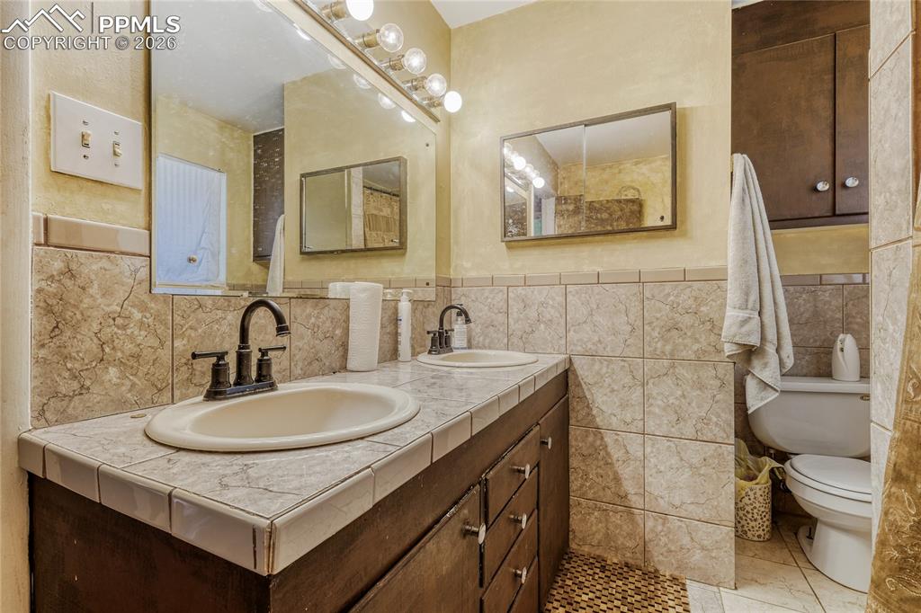 Image 24 of 29: Wood-finish flooring with white baseboards, a wall-mounted mirror, and a ce