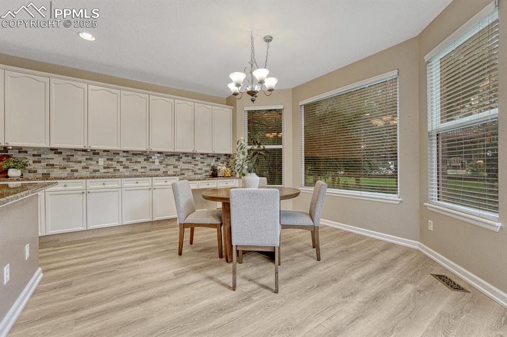 Image 15 of 50: Dining room featuring a chandelier, light wood-type flooring, and recessed