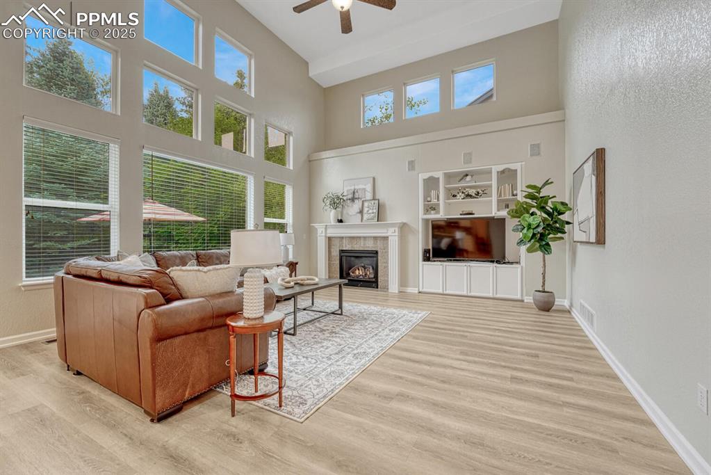 Image 16 of 50: Living area with a ceiling fan, a high ceiling, healthy amount of natural l
