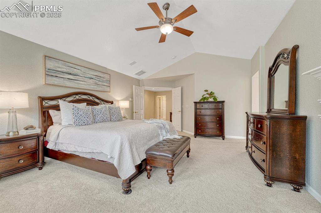 Image 25 of 50: Bedroom with light carpet, vaulted ceiling, and ceiling fan