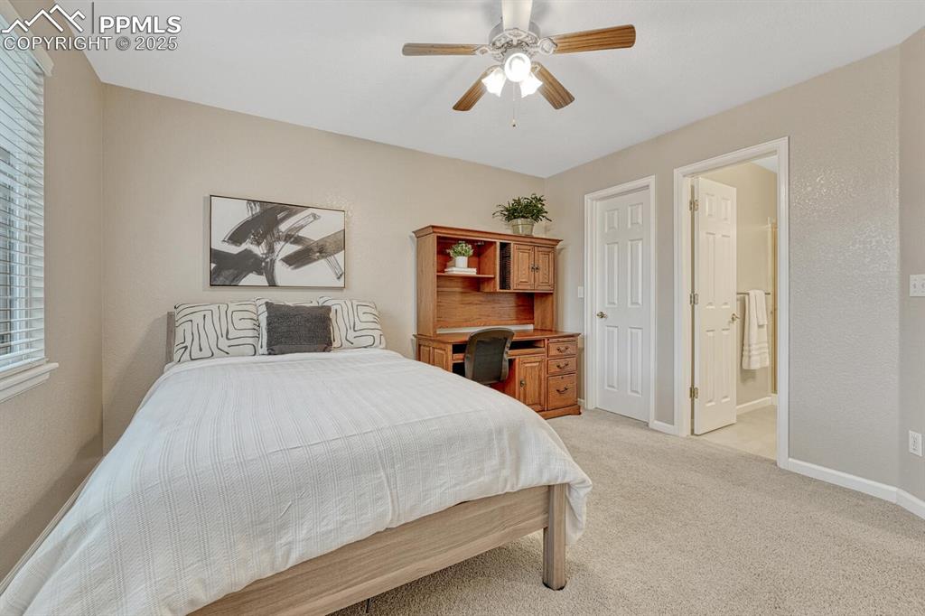 Image 34 of 50: Bedroom with light carpet, a ceiling fan, and ensuite bathroom