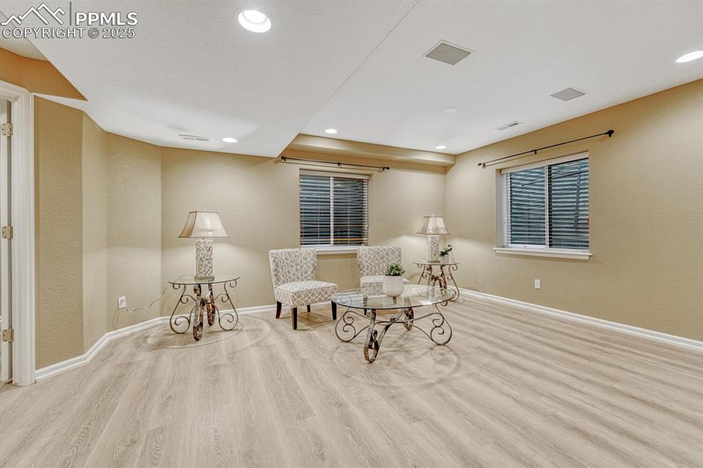 Image 37 of 50: Sitting room with wood finished floors and recessed lighting