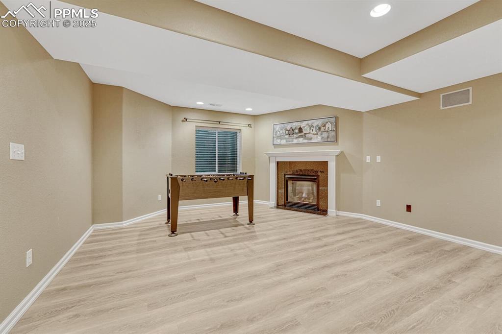 Image 40 of 50: Unfurnished living room featuring light wood finished floors, a tile firepl