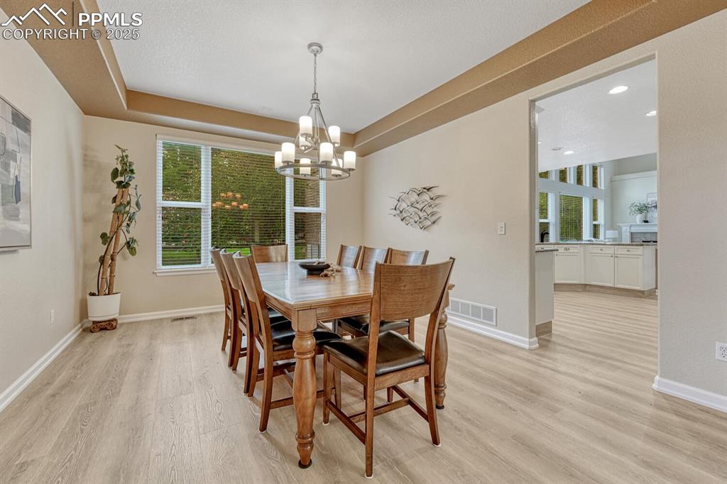 Image 6 of 50: Dining space with light wood-style flooring, a chandelier, and recessed lig