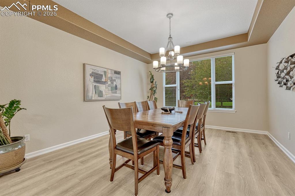 Image 7 of 50: Dining room featuring a chandelier and light wood-style flooring