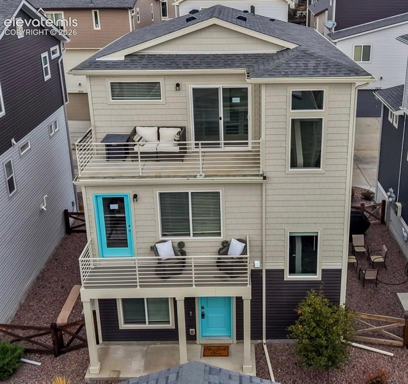 Caption: Multi-level residence featuring dual stacked balconies with metal railings, shingle and horizontal s