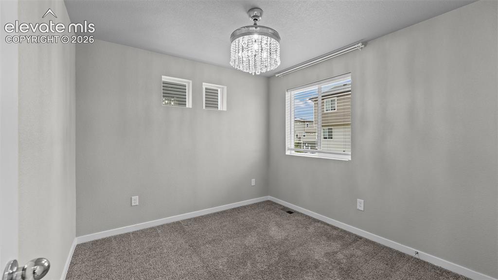 Image 17 of 34: Neutral-toned interior space featuring wall-to-wall carpeting, a crystal-ac