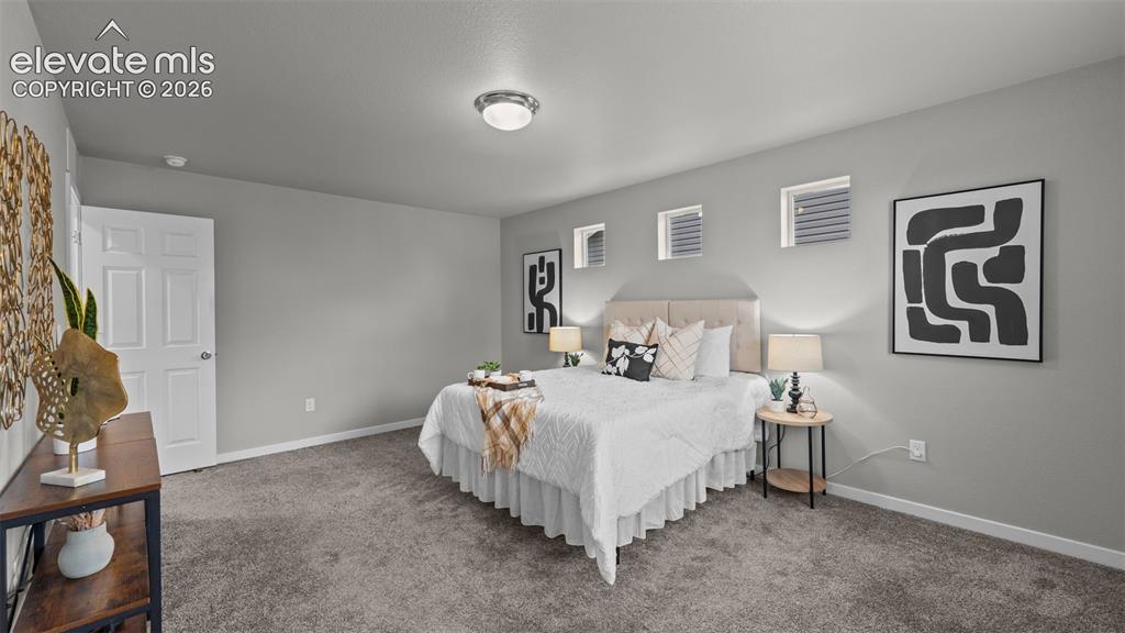 Image 26 of 34: Neutral-toned interior space featuring carpeting, smooth-finish walls, thre