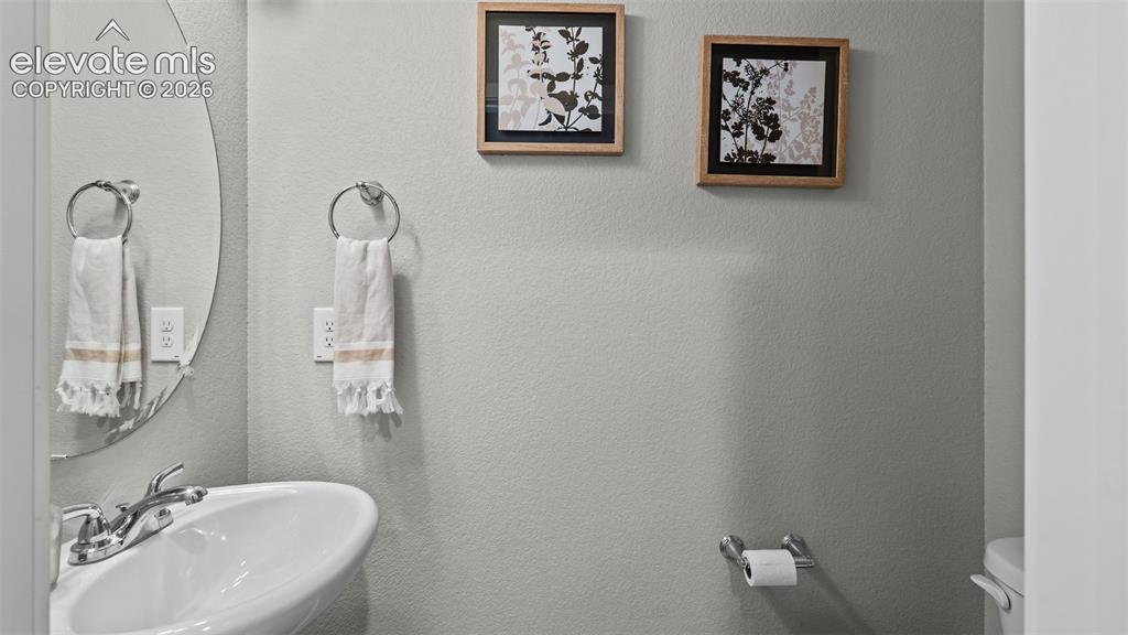 Image 5 of 34: Oval wall-mounted mirror, white pedestal sink, polished chrome faucet, circ