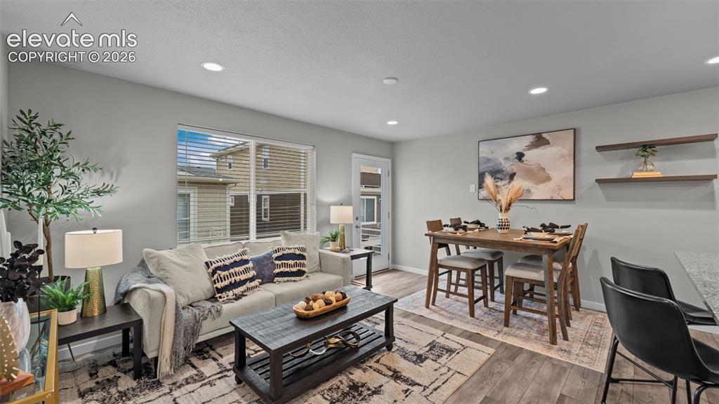 Image 6 of 34: Open-concept living space featuring wood-finish flooring, recessed lighting