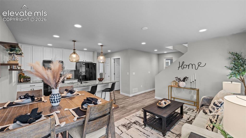 Image 8 of 34: Open-concept kitchen featuring white cabinetry, stone-finish countertops, r