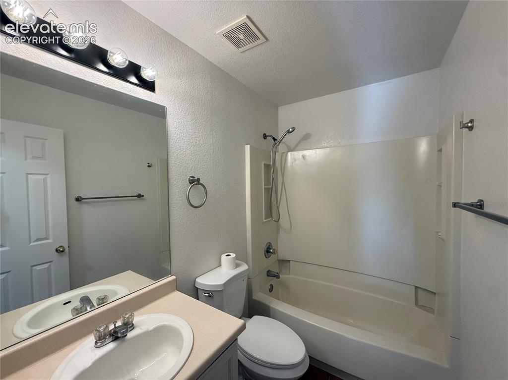 Image 16 of 20: Full bathroom featuring a vanity with an integrated sink, a large wall-moun