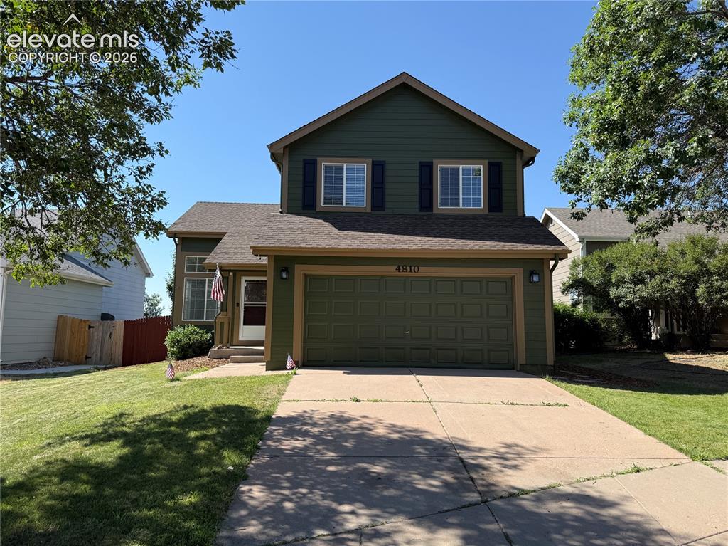 Image 5 of 20: Two-story residence featuring green siding with complementary trim