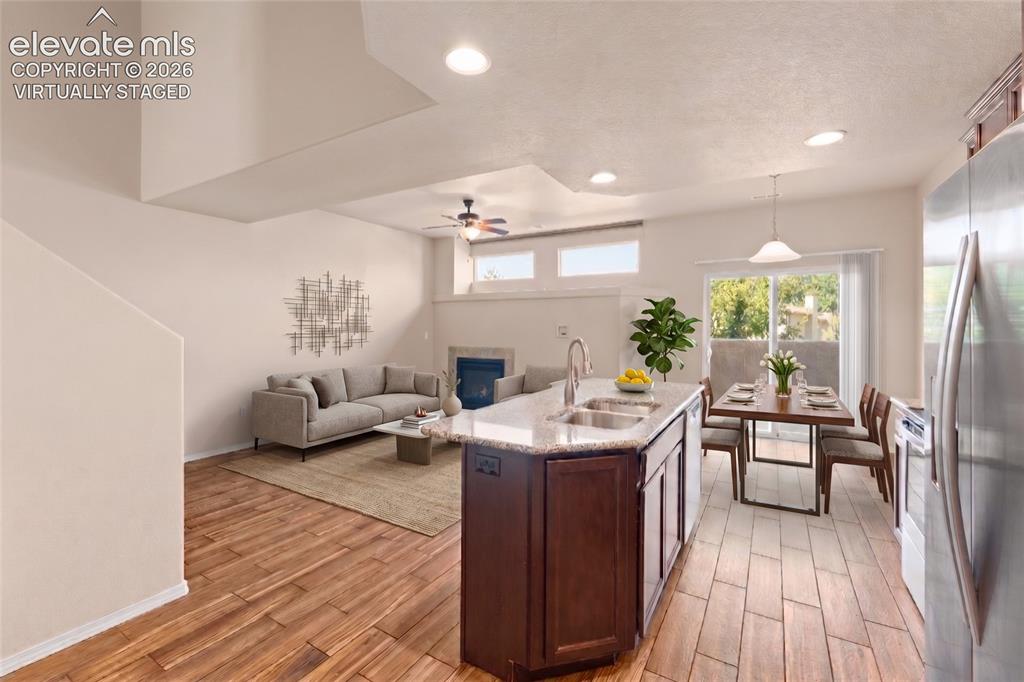 Image 12 of 42: Open-concept living area featuring wood-finish flooring, a kitchen island w