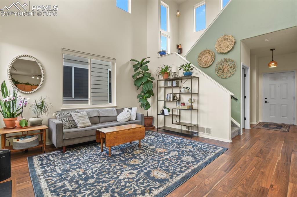 Image 4 of 30: Living room with high ceilings and lots of windows letting the natural ligh