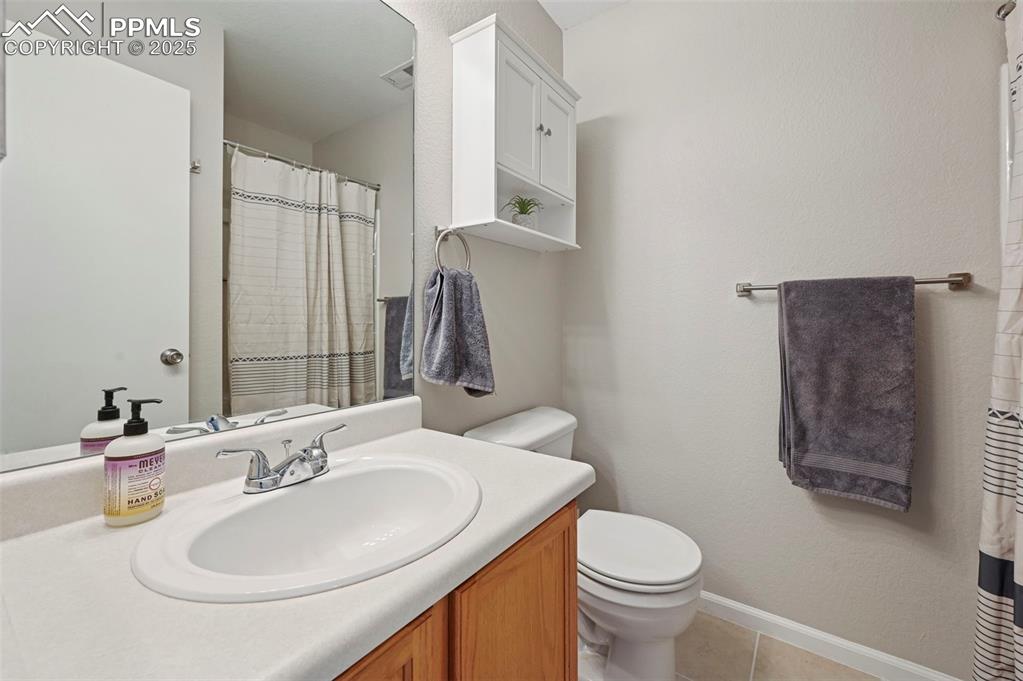 Image 15 of 24: Bathroom featuring curtained shower, vanity, and light tile patterned floor
