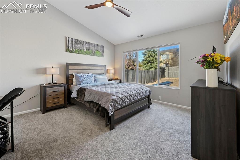 Image 16 of 24: Carpeted bedroom featuring lofted ceiling and ceiling fan