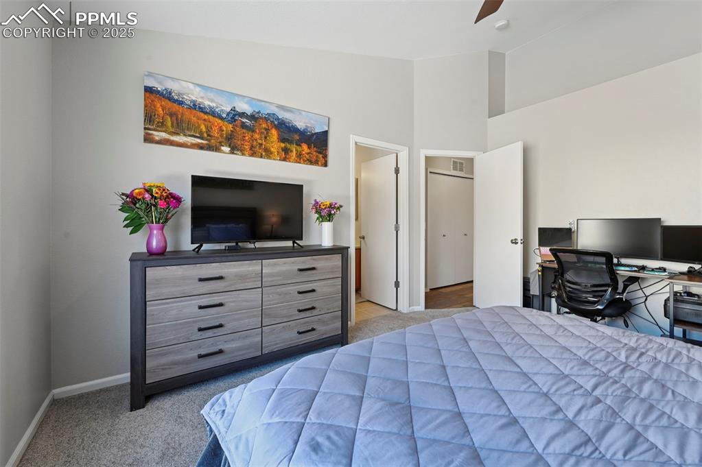 Image 18 of 24: Bedroom featuring an office area, light colored carpet, lofted ceiling, and