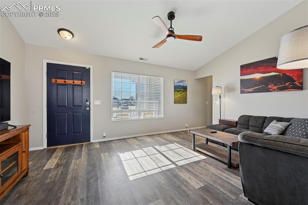 Image 8 of 24: Living room featuring vaulted ceiling, a ceiling fan, and dark wood-type fl